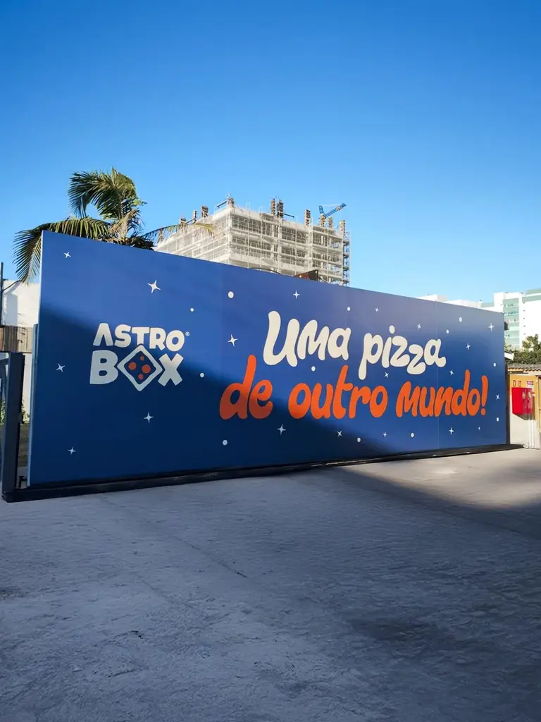 Tapume adesivado de grande formato da Astro Box com a frase Uma pizza de outro mundo
